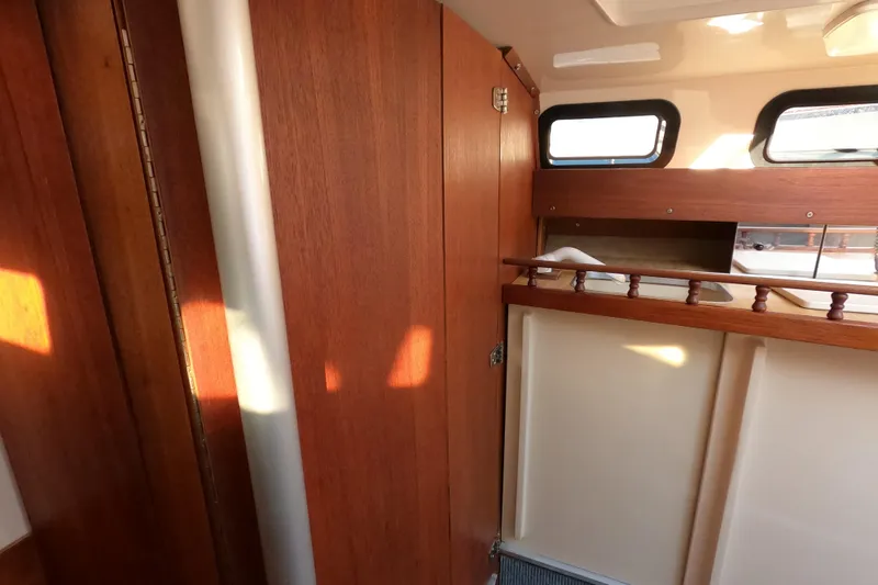 Slide: The Image of Interior of a 1996 Rhodes 22 sailboat with wooden paneling and windows. - 8
