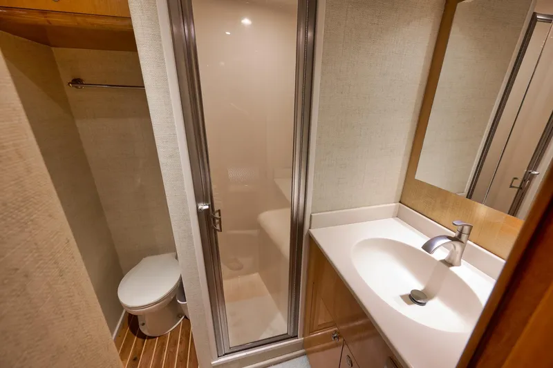 Slide: The Image of Compact bathroom in 2002 Weaver 60 Convertible yacht with shower, sink, and toilet. - 19