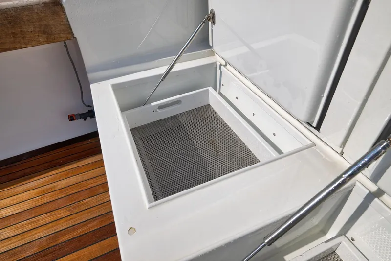 Slide: The Image of Open storage compartment on 2002 Weaver 60 Convertible boat with wooden deck. - 56