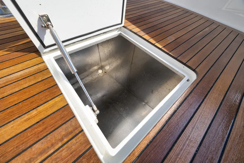 Slide: The Image of Open storage compartment on Weaver 60 Convertible yacht, 2002 model, with wooden deck. - 58