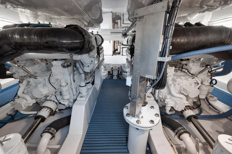 Slide: The Image of Engine room of 2002 Weaver 60 Convertible yacht, featuring dual engines and mechanical components. - 67