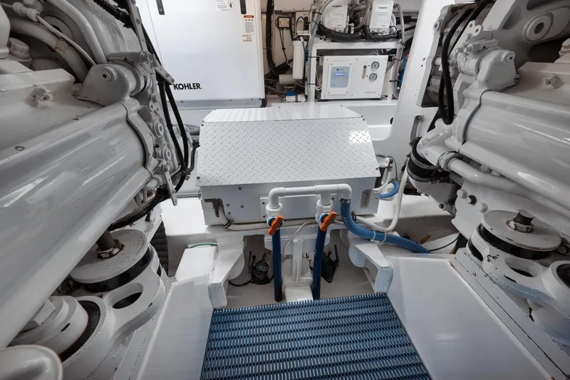 Slide: The Image of Engine room of a 2002 Weaver 60 Convertible yacht, featuring mechanical components and equipment. - 70