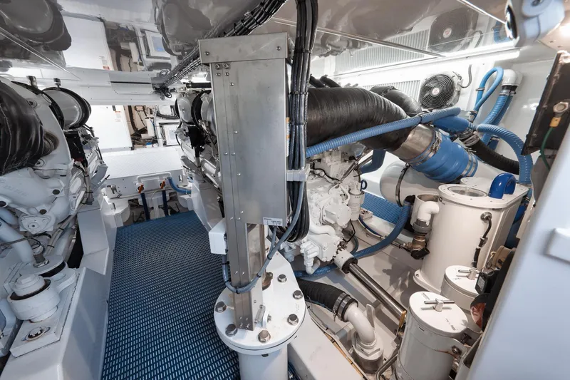 Slide: The Image of Engine room of a 2002 Weaver 60 Convertible yacht, featuring complex machinery and piping. - 75