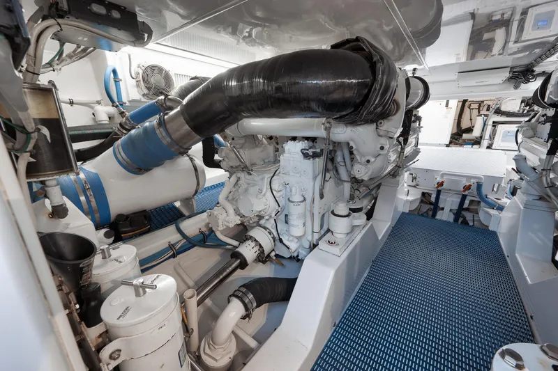 Slide: The Image of Engine room of a 2002 Weaver 60 Convertible yacht, featuring complex machinery and piping. - 76