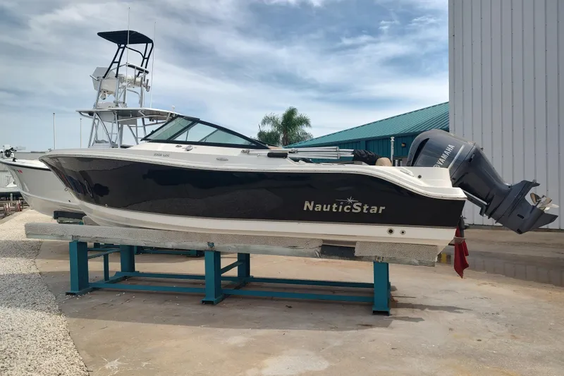 Slide: The Image of 2019 NauticStar 2302 Legacy Dual Console boat on display with Yamaha outboard motor. - 15