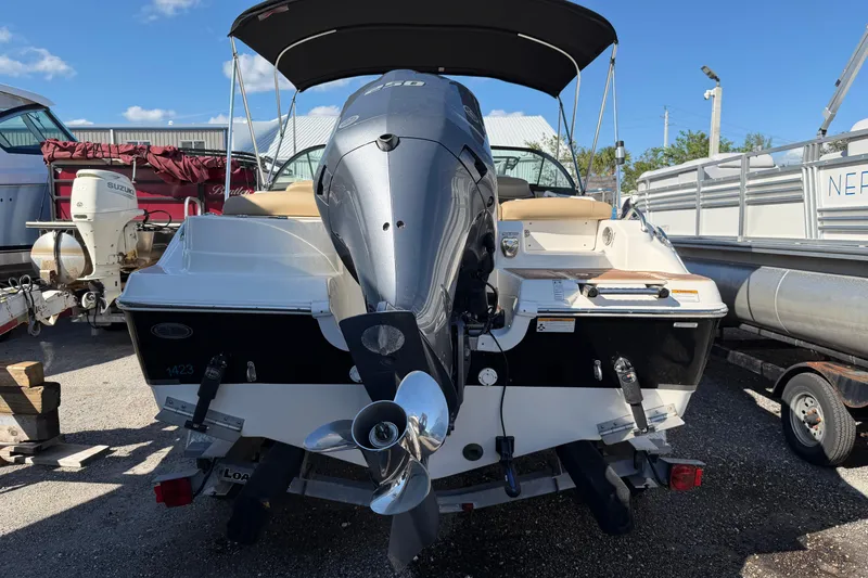 Slide: The Image of 2019 NauticStar 2302 Legacy Dual Console boat with outboard motor, docked outdoors. - 4