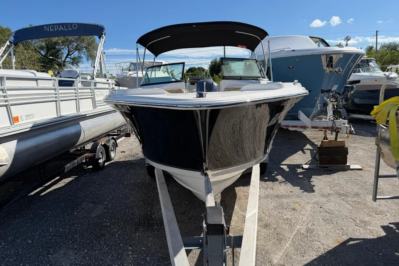 Slide: The Image of 2019 NauticStar 2302 Legacy Dual Console boat on trailer, parked outdoors. - 6