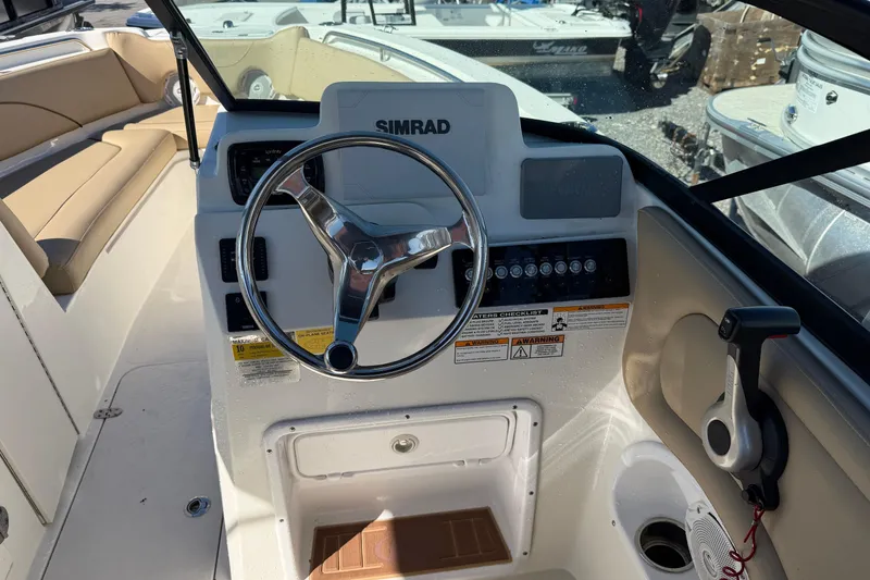 Slide: The Image of 2019 NauticStar 2302 Legacy Dual Console boat dashboard with steering wheel and controls. - 8