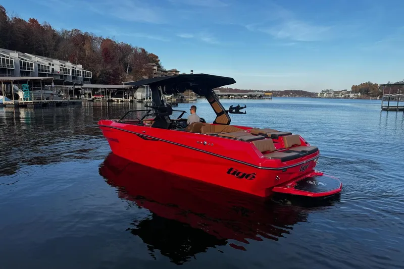 Slide: The Image of 2026 Tigé Z3 boat cruising on water, showcasing sleek red design and modern features. - 2