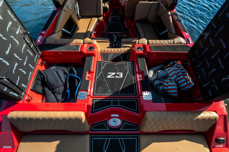 Slide: The Image of 2026 Tigé Z3 boat interior with red accents and tan seating on water. - 21