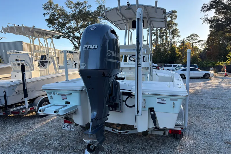 Slide: The Image of 2016 Pathfinder 2200 TRS boat on trailer, parked outdoors near other boats. - 2