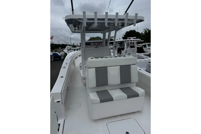 Slide: The Image of 2024 Invincible 36 Open Fisherman boat with cushioned seating and T-top, docked outdoors. - 3