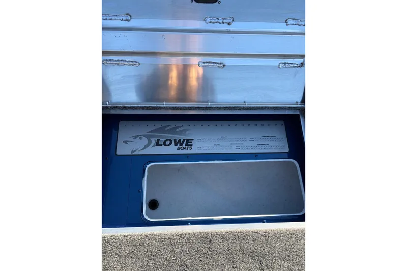 Slide: The Image of 2026 Lowe Fishing Machine 1775WT boat storage compartment with logo and measurement guide. - 11