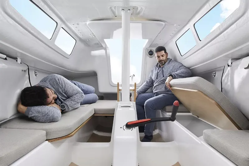 Slide: The Image of Manufacturer Provided Image: Interior of 2026 Beneteau First 24 sailboat with two people relaxing inside. - 4