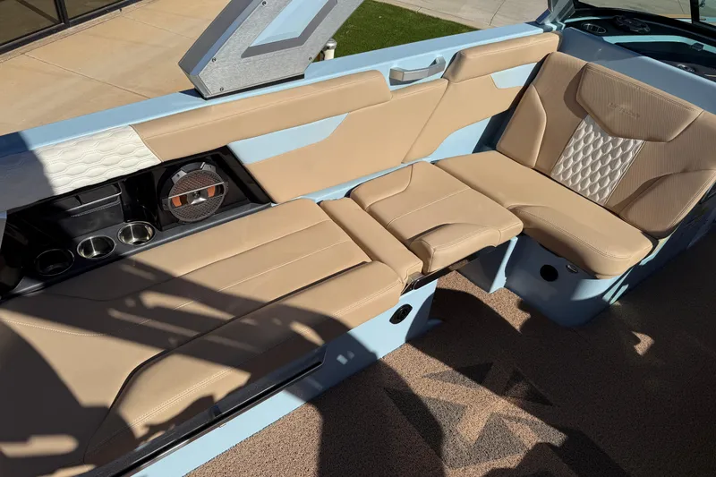 Slide: The Image of 2022 MasterCraft XT24 boat interior with beige seating and cup holders. - 12