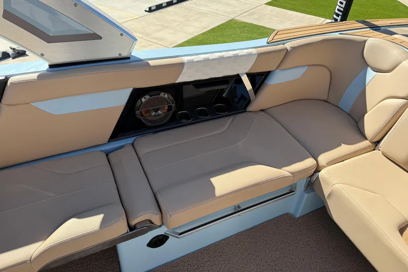 Slide: The Image of 2022 MasterCraft XT24 boat interior with beige seating and built-in speaker system. - 13