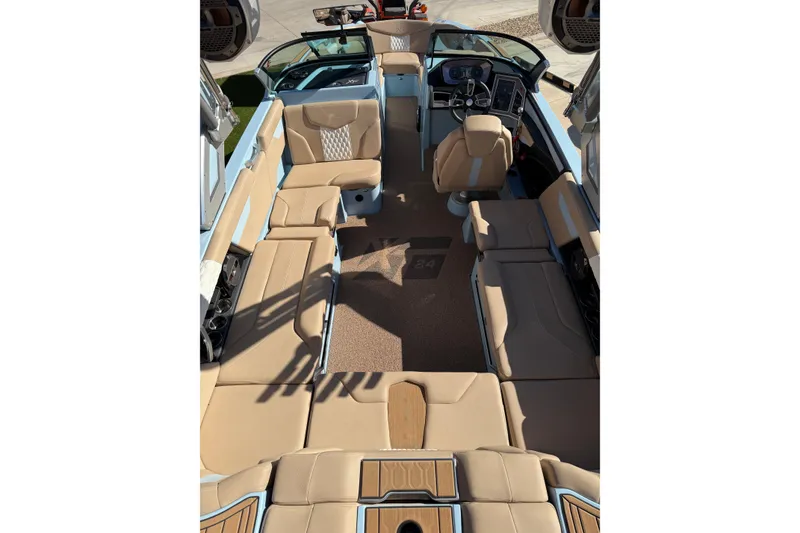 Slide: The Image of 2022 MasterCraft XT24 boat interior with beige seating and modern dashboard. - 14