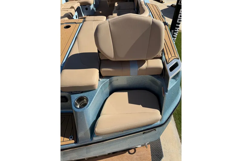 Slide: The Image of 2022 MasterCraft XT24 boat interior with beige seating and cup holder. - 16