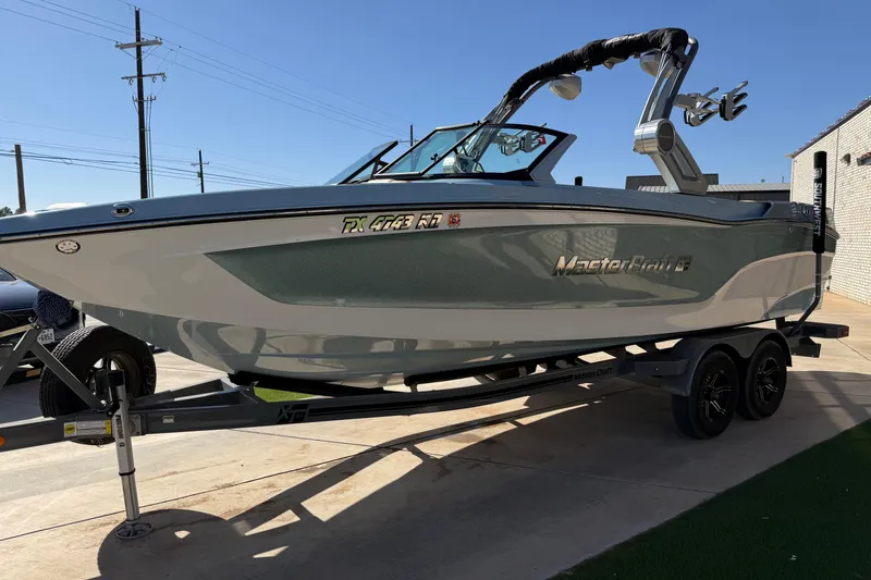 Slide: The Image of 2022 MasterCraft XT24 boat on trailer, sleek design, parked outdoors. - 4