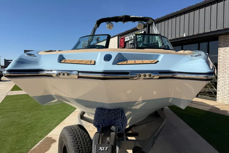 Slide: The Image of 2022 MasterCraft XT24 boat on trailer, displayed outdoors with blue and white hull. - 5
