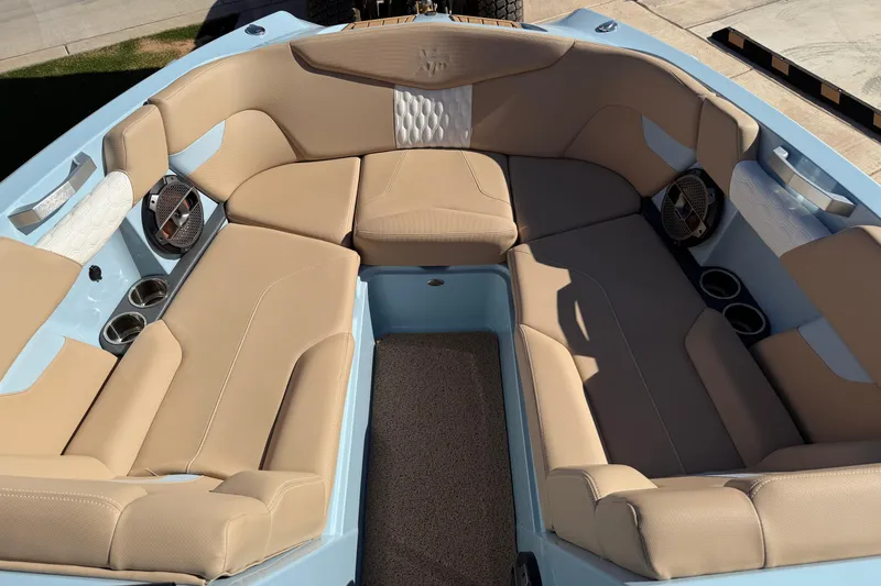 Slide: The Image of 2022 MasterCraft XT24 boat interior with beige seating and built-in speakers. - 9
