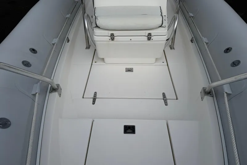 Slide: The Image of Interior of a 2006 HBI 22 boat, featuring white seating and deck. - 6