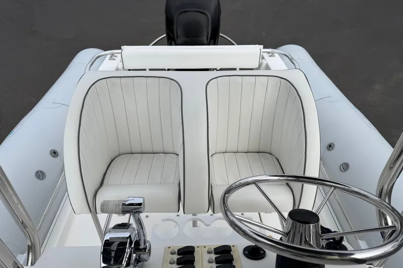 Slide: The Image of Steering console of 2006 HBI 22 boat with white cushioned seats and controls. - 9