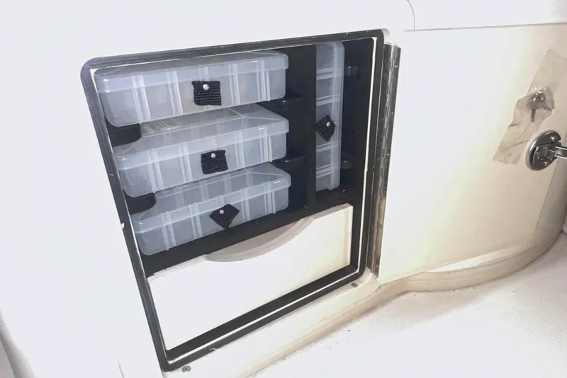 Slide: The Image of Storage compartment with tackle boxes on a 2021 Grady-White Fisherman 216 boat. - 19