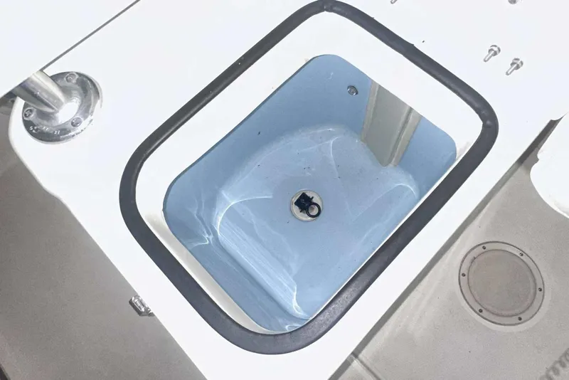 Slide: The Image of Livewell compartment on a 2021 Grady-White Fisherman 216 boat, featuring a blue interior. - 22