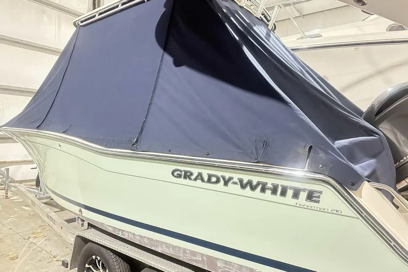 Slide: The Image of 2021 Grady-White Fisherman 216 boat with blue cover on trailer. - 3