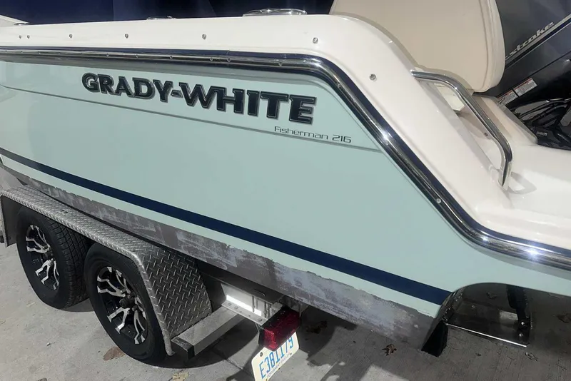 Slide: The Image of 2021 Grady-White Fisherman 216 boat on a trailer, showcasing sleek design and branding. - 6