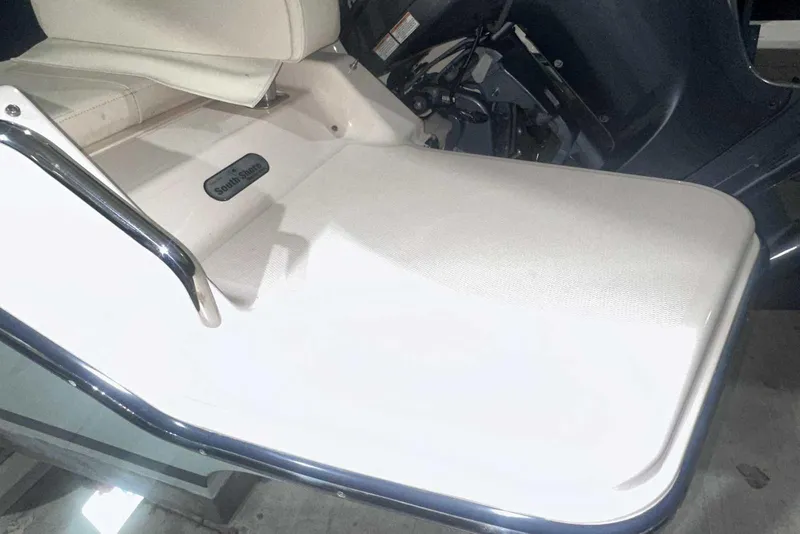 Slide: The Image of 2021 Grady-White Fisherman 216 boat seat and deck detail, featuring stainless steel railing. - 9