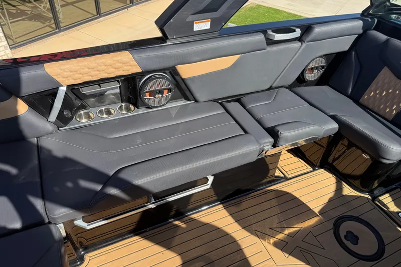 Slide: The Image of 2023 MasterCraft XT24 boat interior with sleek seating and integrated speakers. - 11