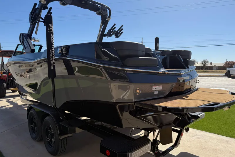 Slide: The Image of 2023 MasterCraft XT24 boat on trailer, sleek design, outdoor setting. - 17