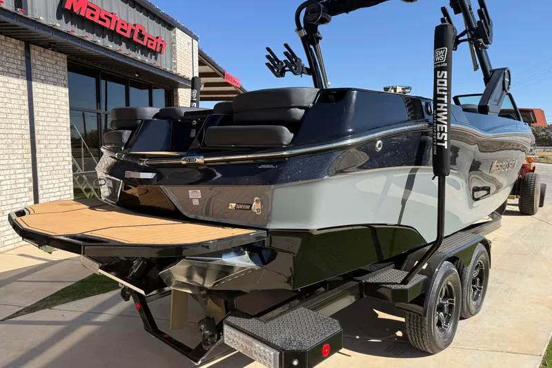 Slide: The Image of 2023 MasterCraft XT24 boat on trailer outside dealership, showcasing sleek design and features. - 20