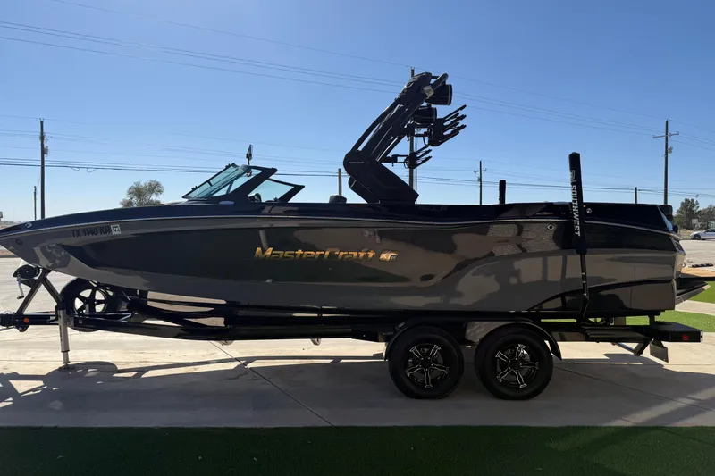Slide: The Image of 2023 MasterCraft XT24 boat on trailer, sleek design, parked outdoors. - 3