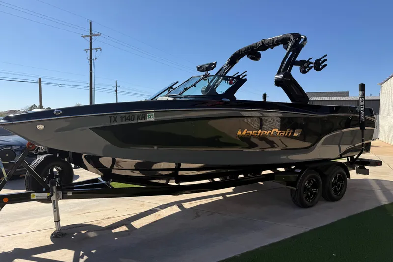 Slide: The Image of 2023 MasterCraft XT24 boat on trailer, sleek design, parked outdoors. - 4