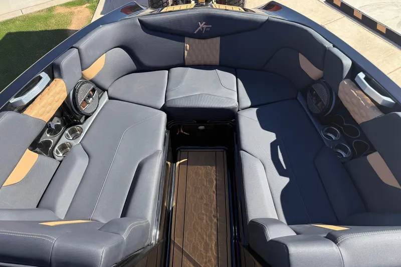 Slide: The Image of 2023 MasterCraft XT24 boat interior with luxurious seating and cup holders. - 7