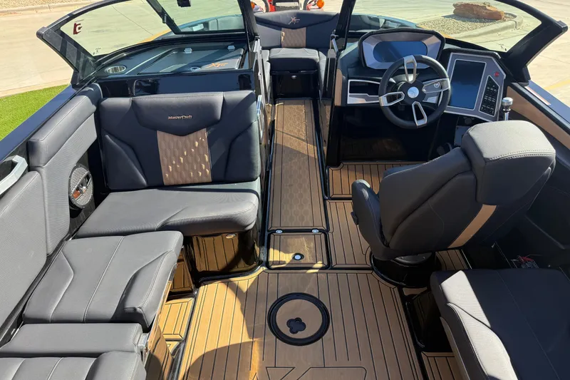 Slide: The Image of 2023 MasterCraft XT24 boat interior with luxurious seating and modern dashboard design. - 8