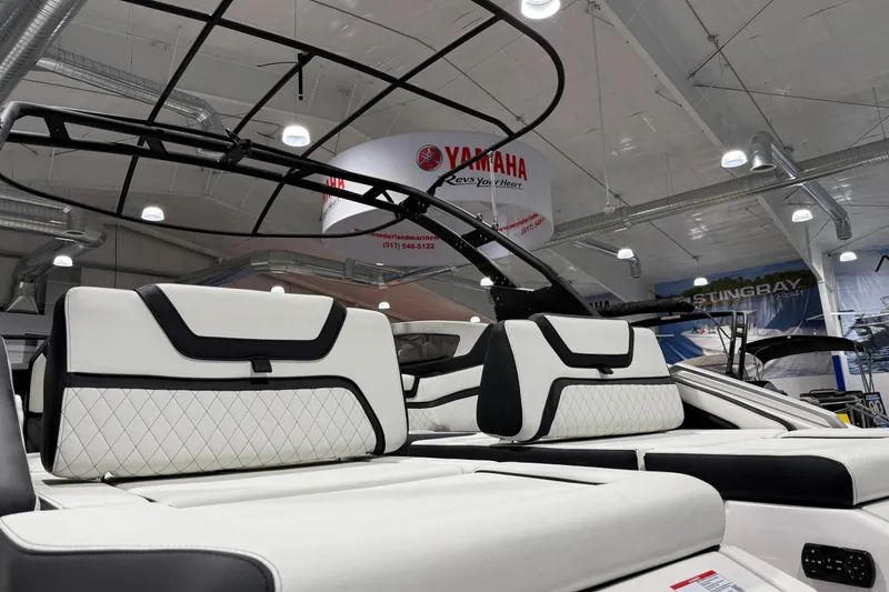 Slide: The Image of 2025 Yamaha Boats 275SE interior with luxurious white seating at a boat show. - 2