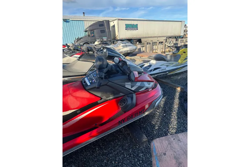 Slide: The Image of 2023 Yamaha WaveRunner VX Deluxe in a parking area with other jet skis. - 4