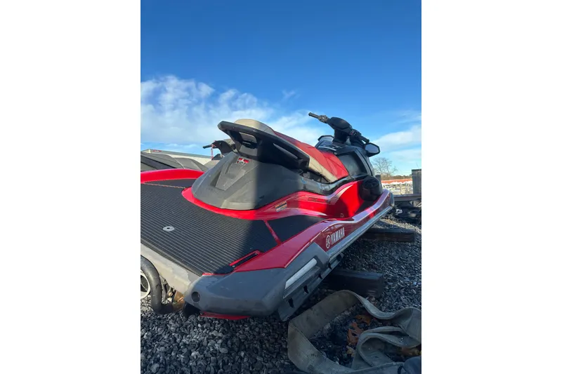 Slide: The Image of 2023 Yamaha WaveRunner VX Deluxe in red, parked on gravel under a clear blue sky. - 7