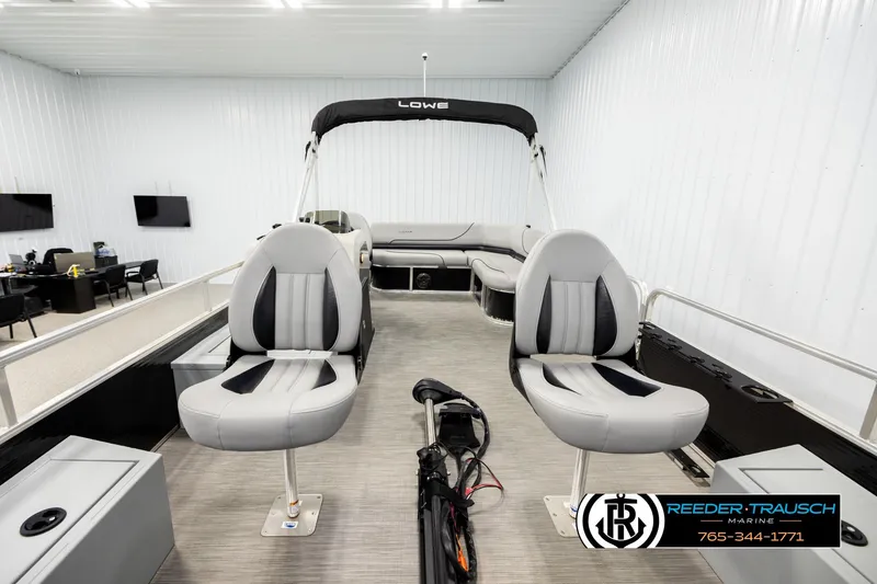 Slide: The Image of 2024 Lowe Ultra 162 Fish & Cruise boat interior with seating and helm in showroom. - 13