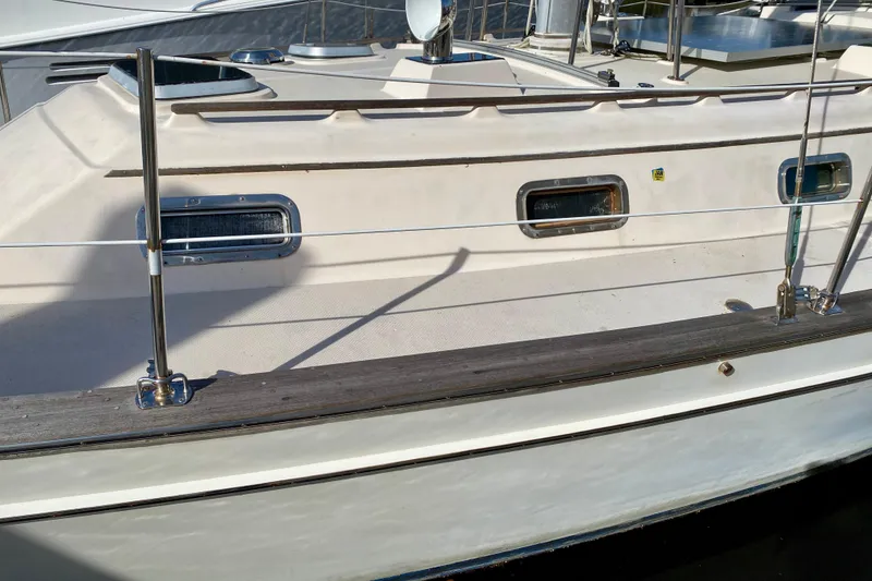 Slide: The Image of 1994 Island Packet 44 sailboat deck with portholes and railing. - 10