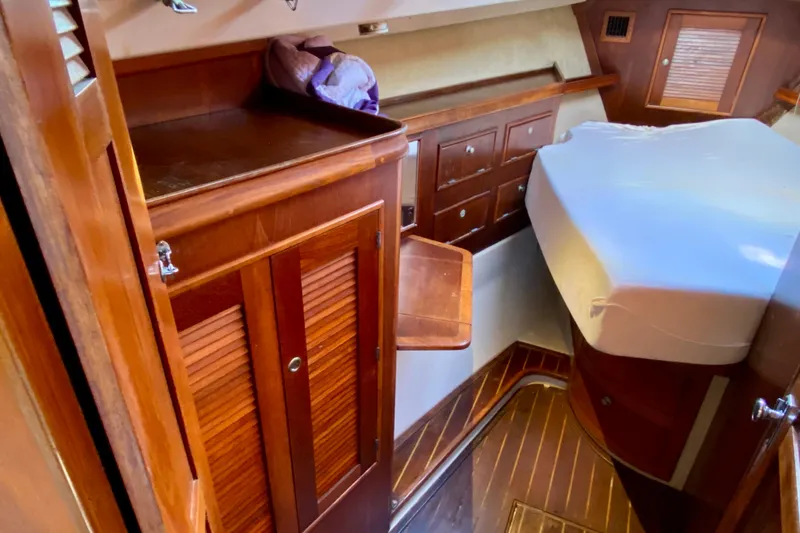 Slide: The Image of Interior of 1994 Island Packet 44 sailboat with wooden cabinetry and bed. - 107