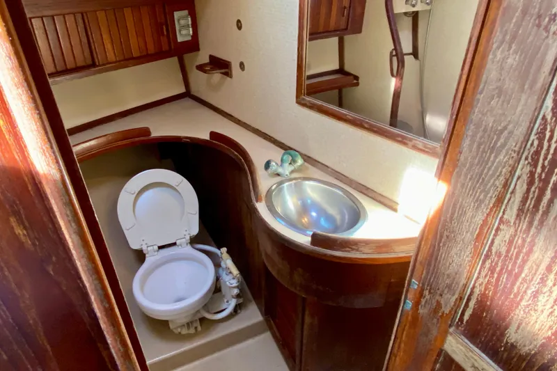 Slide: The Image of 1994 Island Packet 44 yacht bathroom with wooden cabinetry and stainless steel sink. - 112