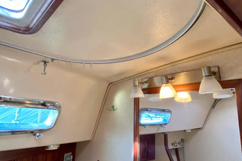 Slide: The Image of Interior of 1994 Island Packet 44 sailboat with lighting and porthole. - 114