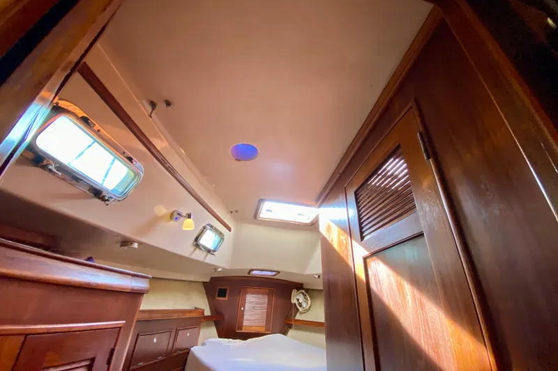 Slide: The Image of Interior cabin of 1994 Island Packet 44 sailboat with wooden finishes and natural light. - 119