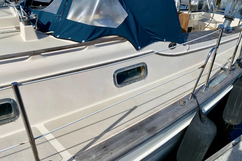 Slide: The Image of 1994 Island Packet 44 sailboat deck with blue canopy and railing. - 12