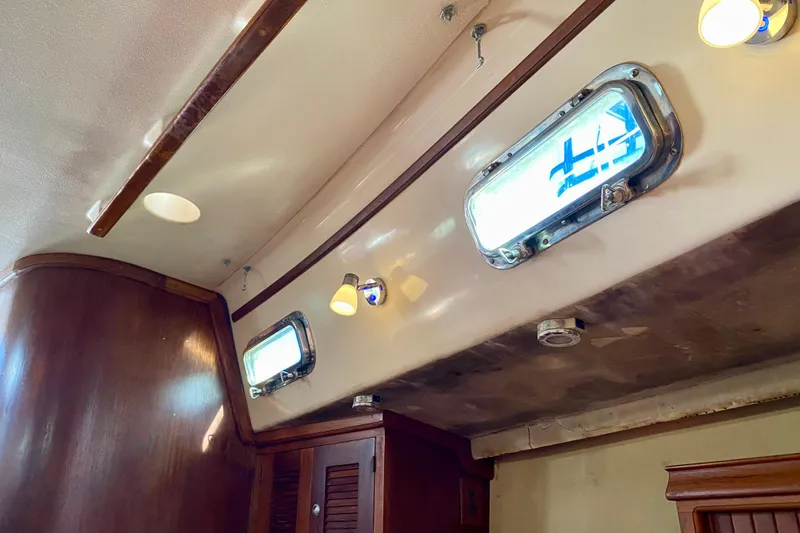 Slide: The Image of Interior of 1994 Island Packet 44 sailboat with wooden paneling and porthole windows. - 122